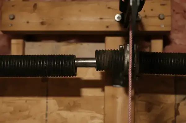 Broken torsion spring on garage door showing dangerous gap