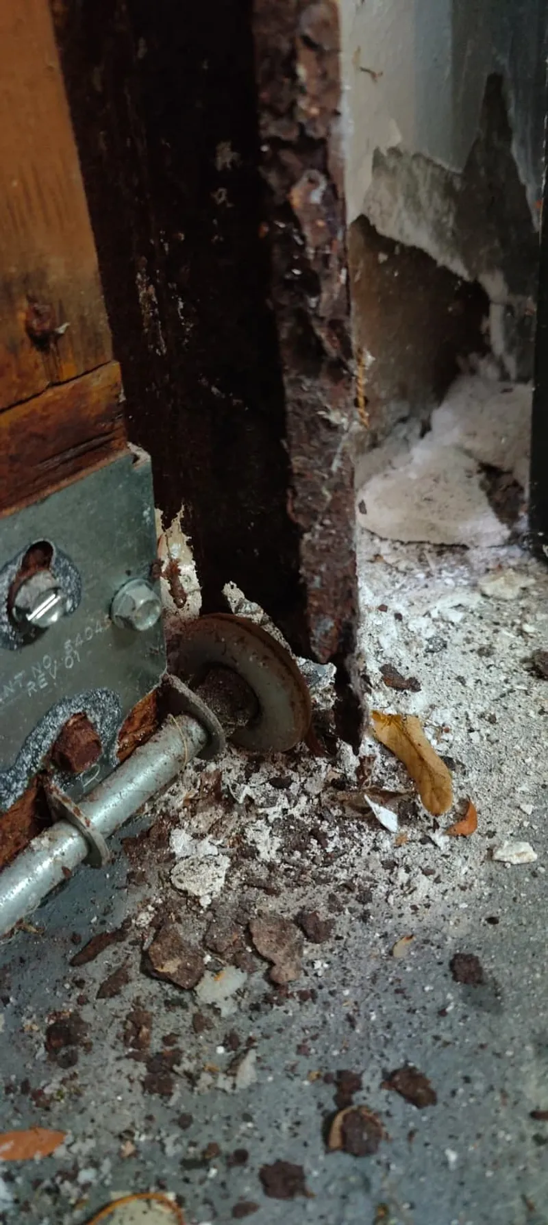 Close up of rusted garage door track at the base showing metal fatigue